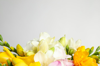 Beautiful colorful freesia bouquet on grey background, closeup. Space for text