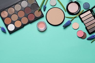 Photo of Flat lay composition with eyeshadow palettes and beautiful flowers on turquoise background, space for text