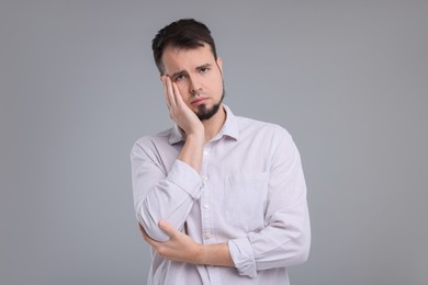 Portrait of sad man on grey background