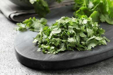 Photo of Cut fresh green cilantro on grey table, closeup