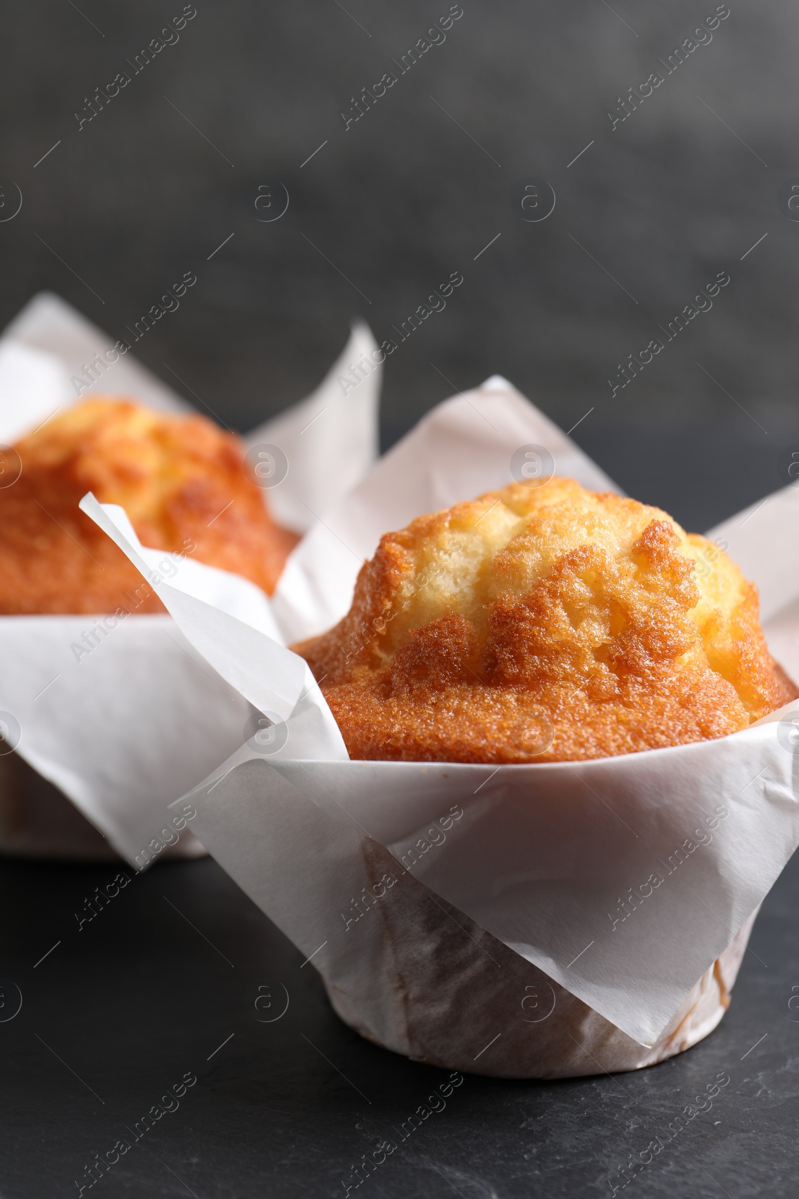 Photo of Tasty muffins on grey table, closeup. Fresh pastry