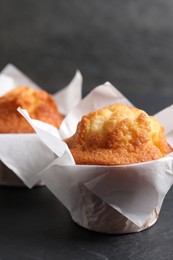 Photo of Tasty muffins on grey table, closeup. Fresh pastry