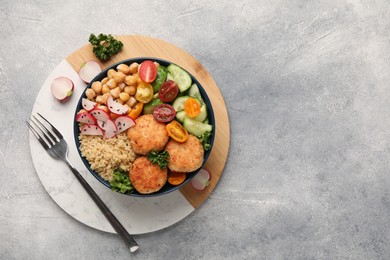 Photo of Delicious vegan bowl with chickpeas, cutlets and radish on grey table, top view. Space for text