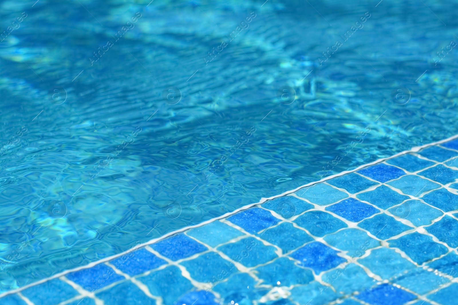 Photo of Clear refreshing water in swimming pool on sunny day, closeup