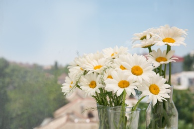 Photo of Vases with beautiful chamomile flowers, closeup
