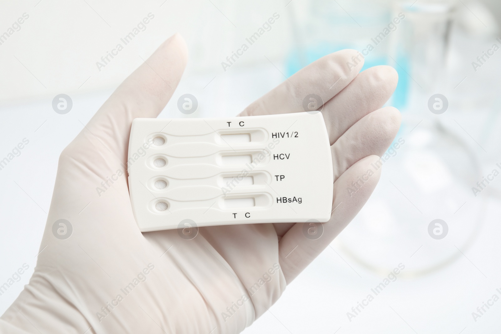 Photo of Doctor holding disposable express test for hepatitis indoors, closeup