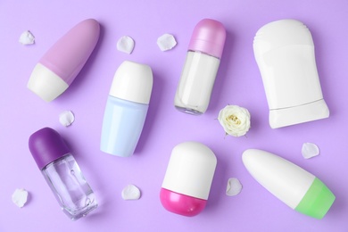 Photo of Flat lay composition with different female deodorants on purple background