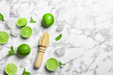 Photo of Flat lay composition with lime, mint and juicer on marble background. Refreshing beverage ingredients