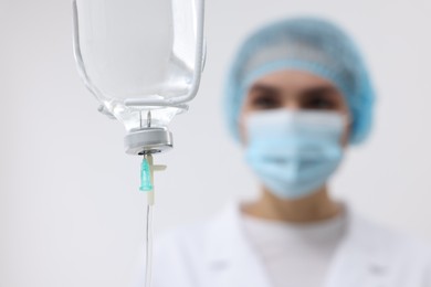 Photo of Setting up IV drip. Nurse on white background, selective focus