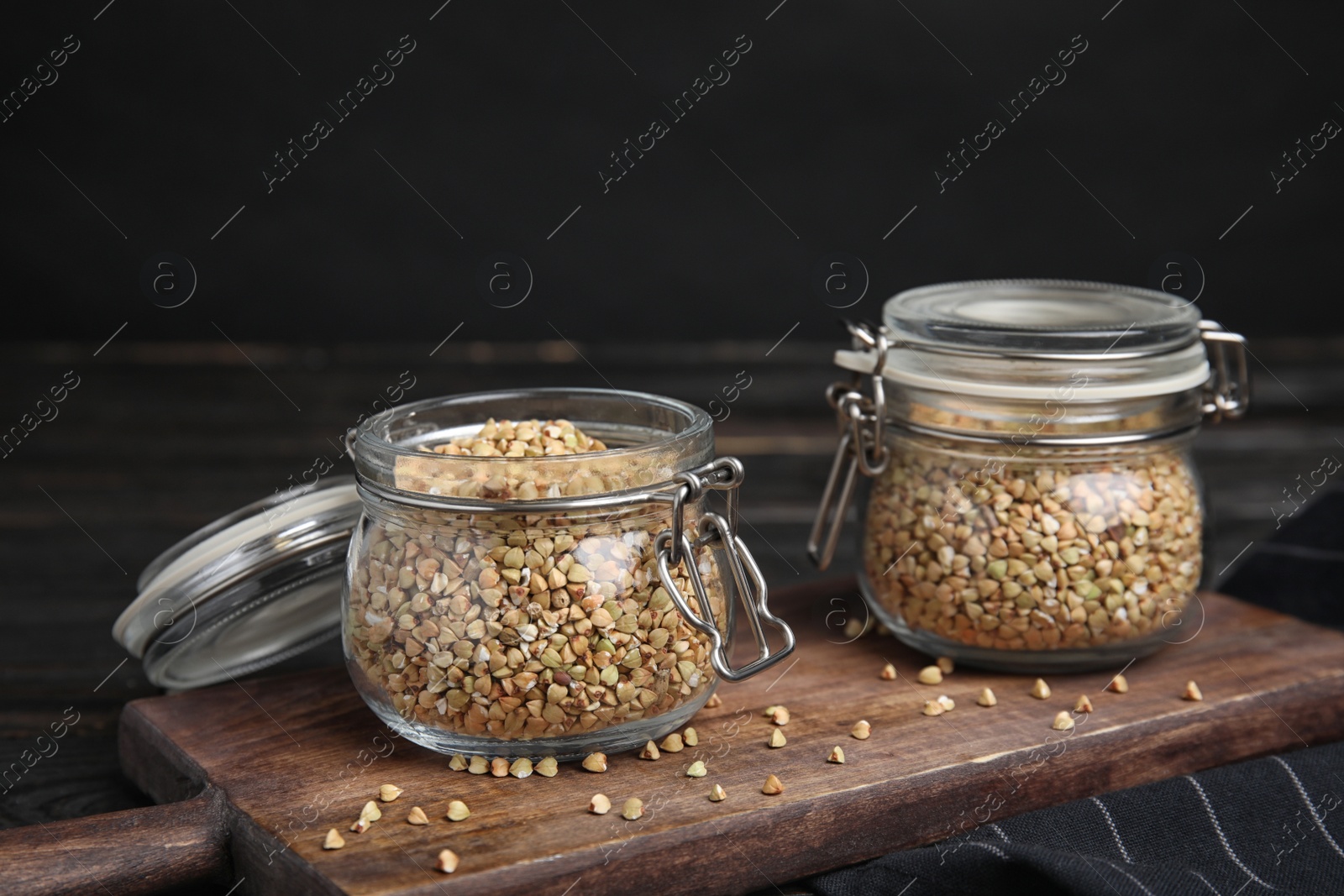 Photo of Jars with green buckwheat on wooden table