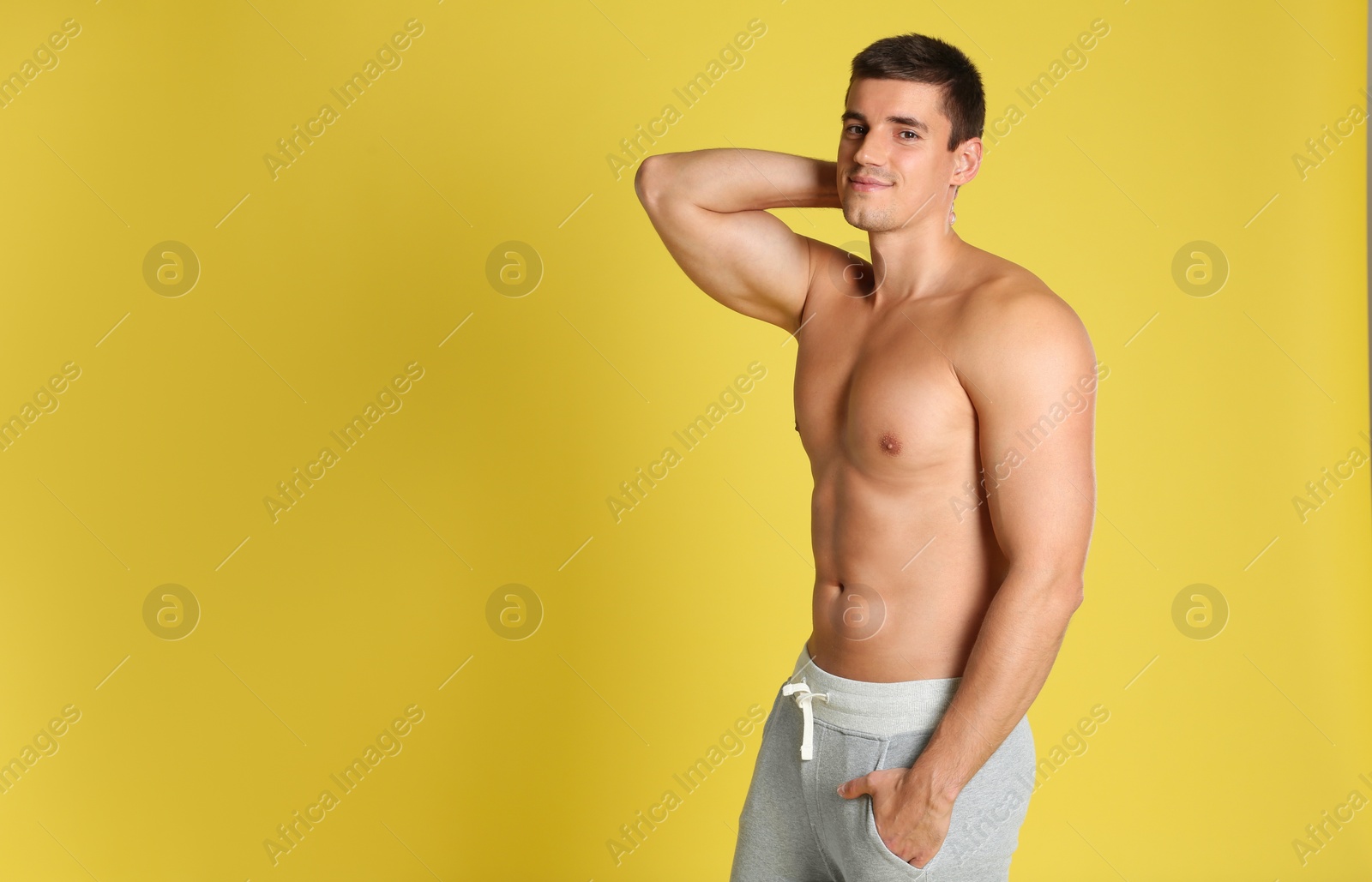 Photo of Man with sexy body on yellow background. Space for text