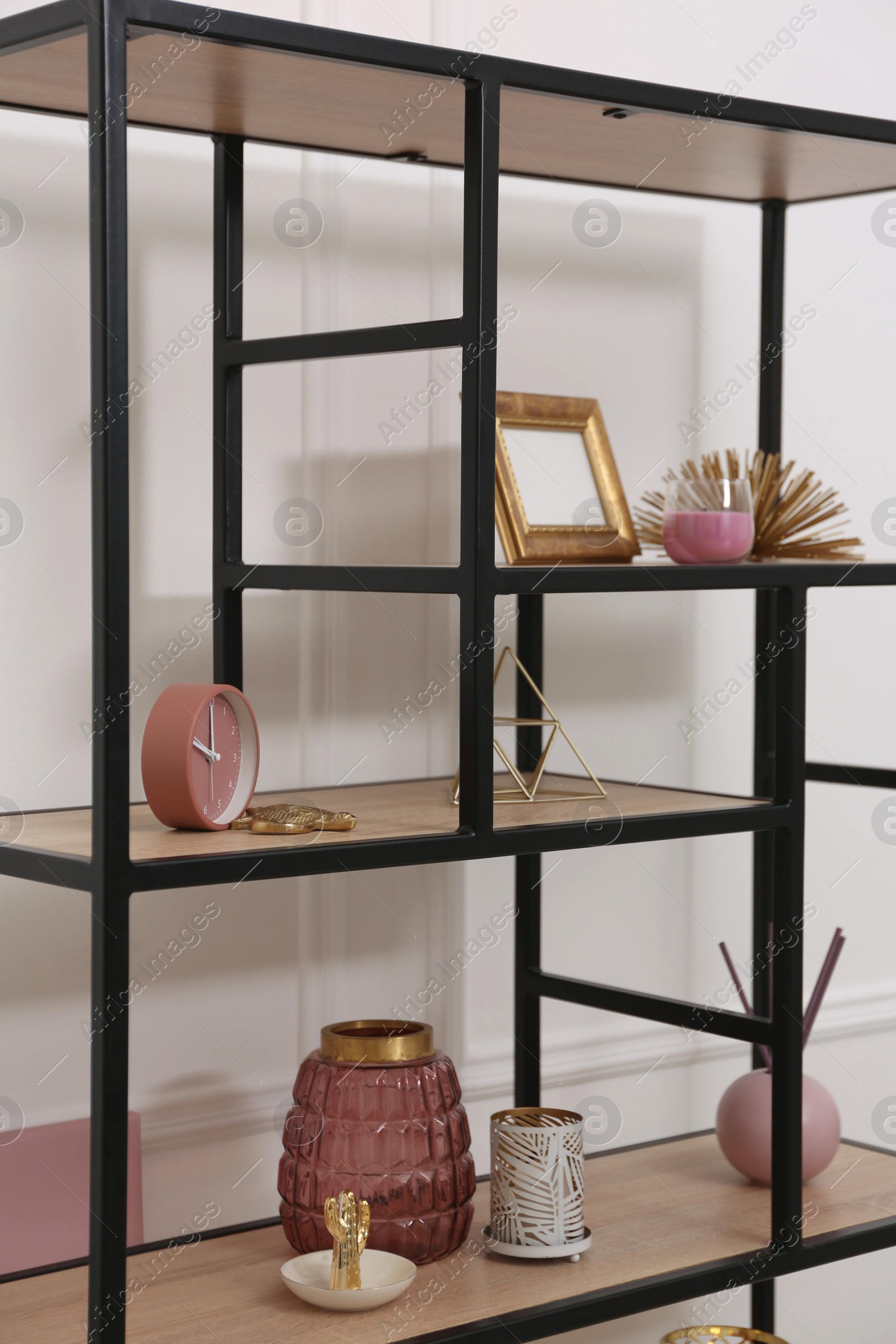 Photo of Stylish shelving unit with different decor near white wall indoors. Interior design