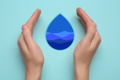 Image of Woman with paper water drop on light blue background, top view