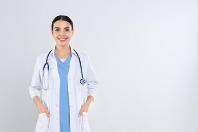 Photo of Portrait of young doctor with stethoscope on white background