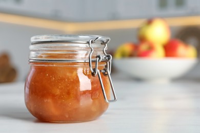 Photo of Delicious apple jam on white table, closeup. Space for text