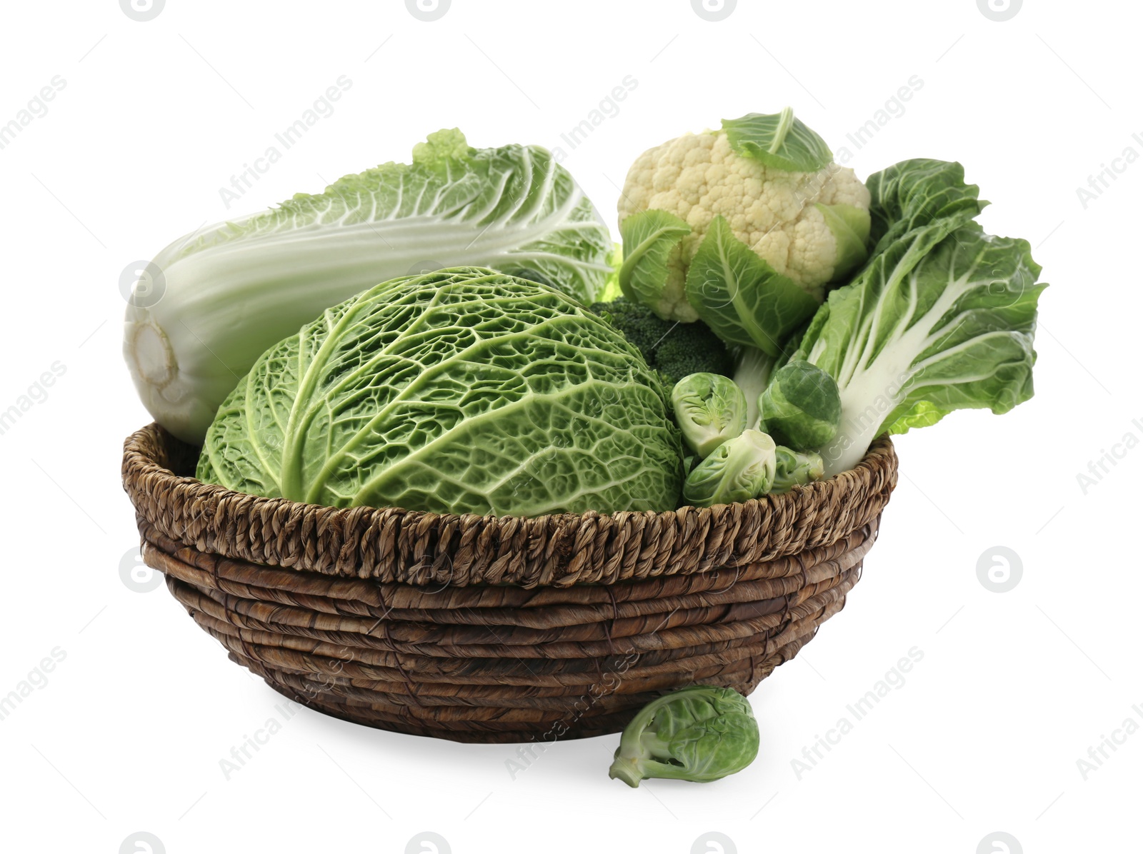 Photo of Wicker bowl with different types of fresh cabbage on white background