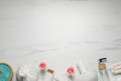 Flat lay composition of herbal bags and spa products on white marble table. Space for text