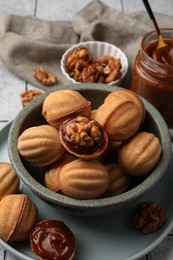 Photo of Delicious nut shaped cookies with boiled condensed milk on table, closeup