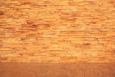 Photo of Beautiful textured stone wall and sidewalk outdoors