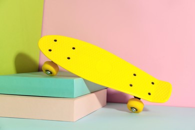 Photo of Yellow skateboard on color background. Sport equipment