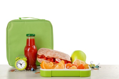 Lunch box with appetizing food and bag on table against white background