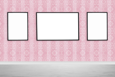 Image of Frames with empty canvases on wall in modern art gallery. Space for design