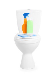 Photo of Different cleaning supplies on toilet bowl against white background