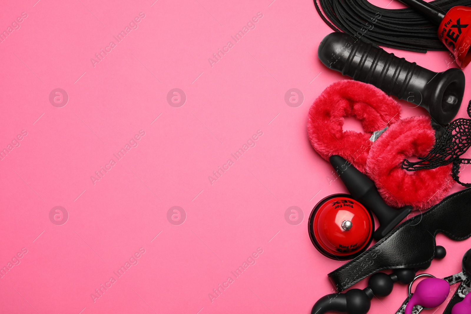 Photo of Different sex toys on pink background, flat lay. Space for text