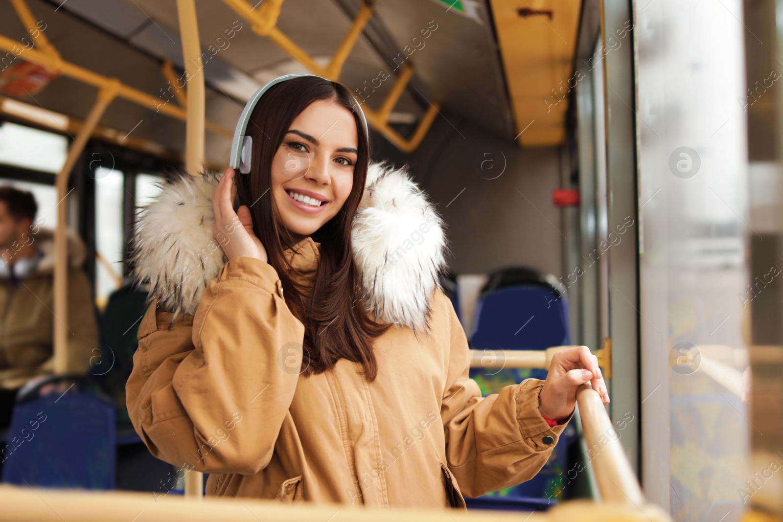 Photo of Young woman listening to music with headphones in public transport