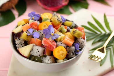 Photo of Delicious exotic fruit salad served on pink table, closeup