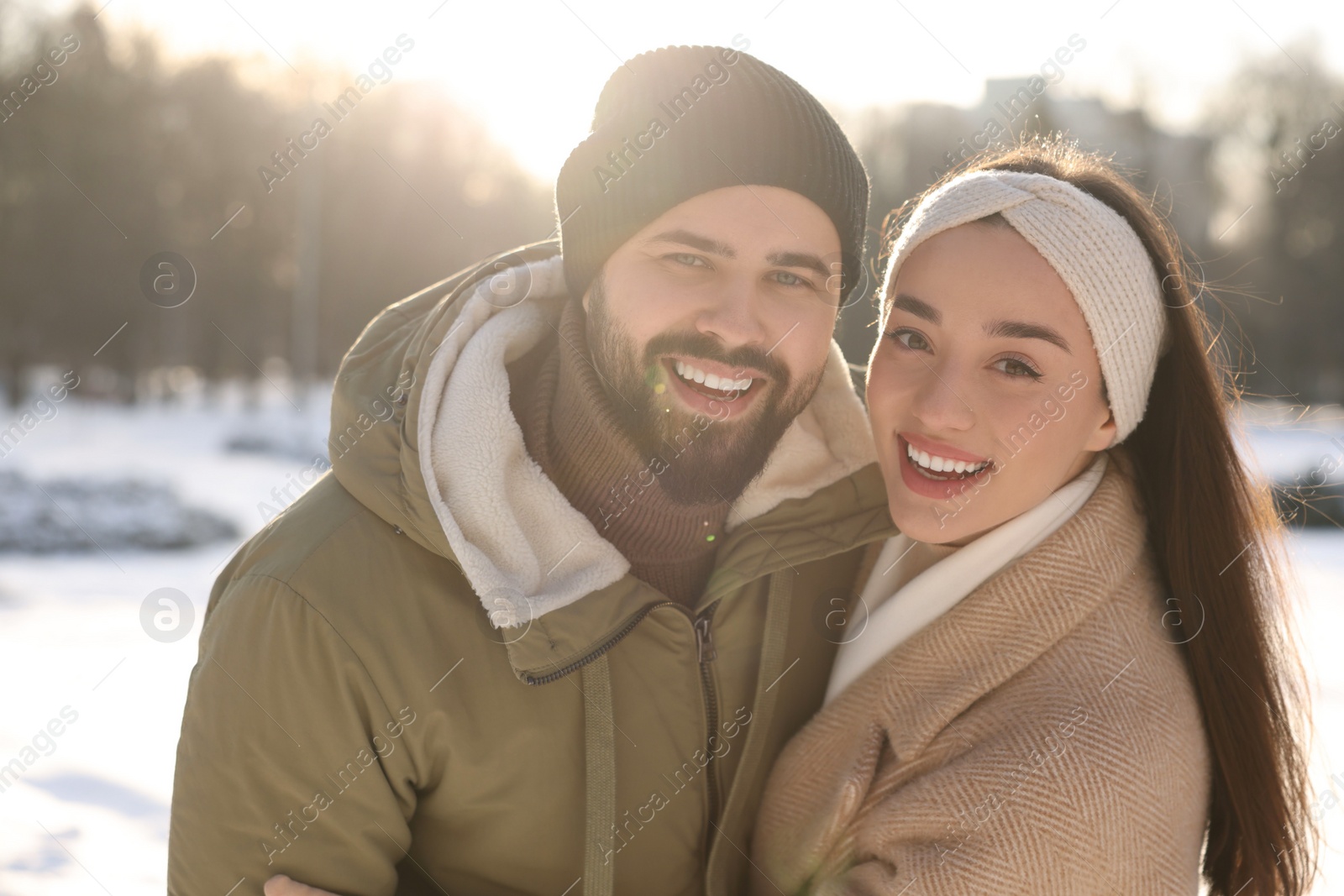 Photo of Beautiful happy couple in snowy park on winter day