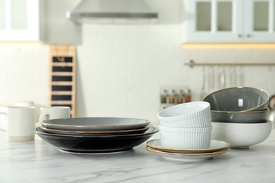 Set of ceramic tableware on white marble table in kitchen