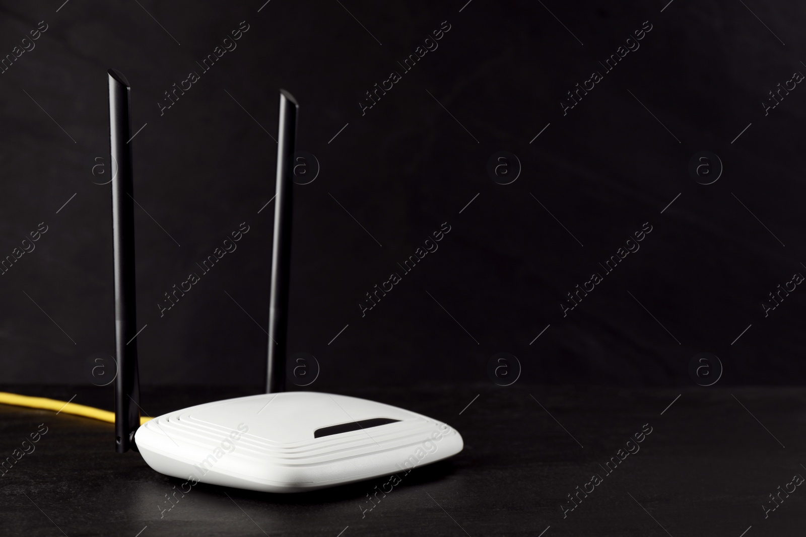 Photo of Modern wireless Wi-Fi router on black background. Space for text