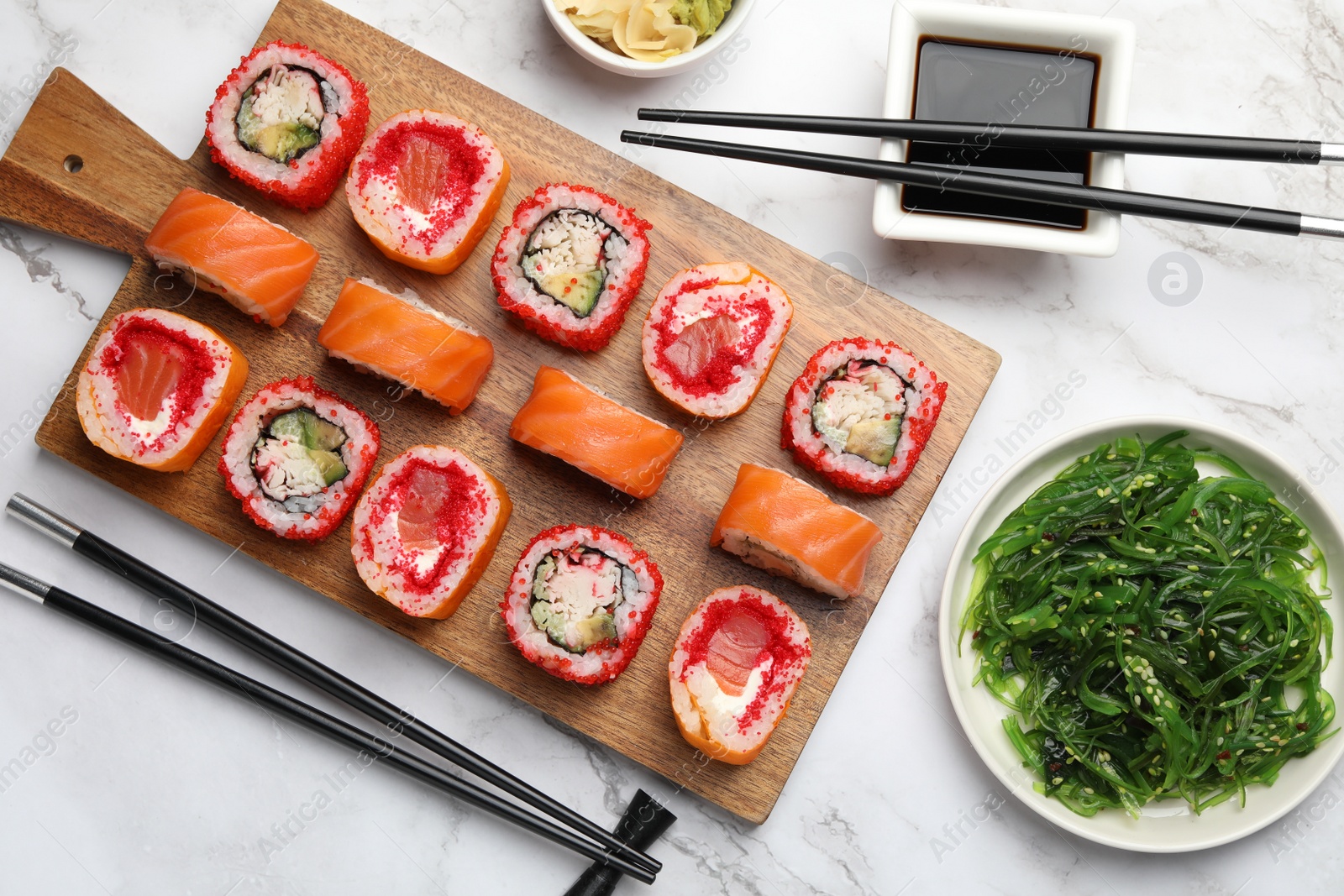 Photo of Flat lay composition with delicious sushi rolls on white marble table