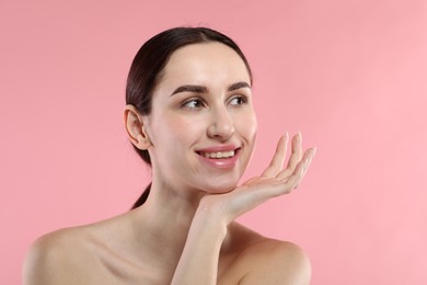 Portrait of beautiful young woman on pink background