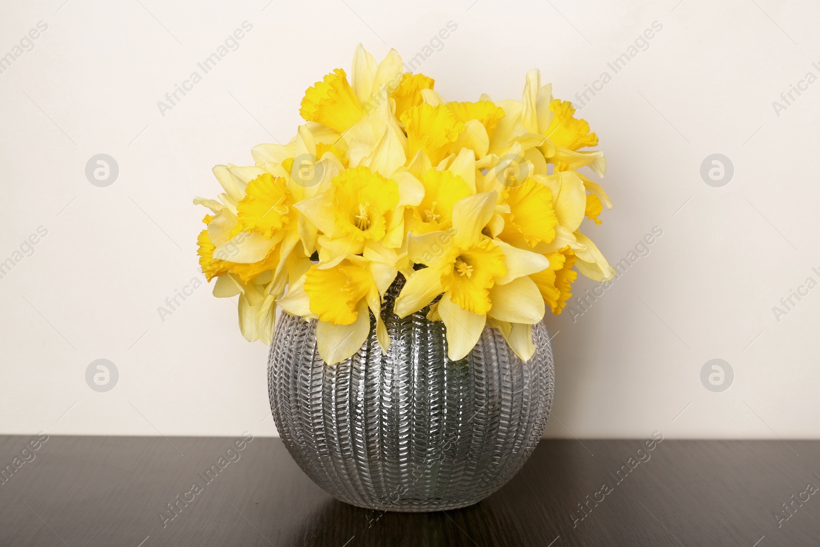 Photo of Bouquet of beautiful yellow daffodils in vase on table
