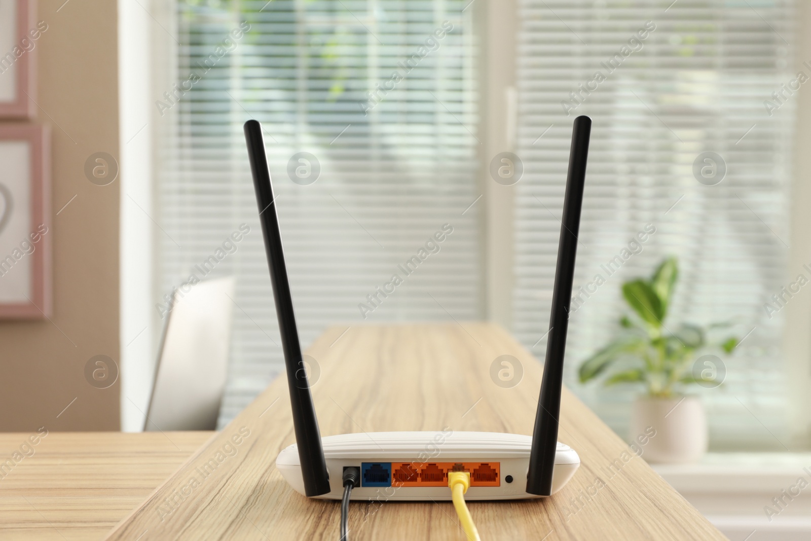 Photo of Modern wi-fi router on wooden counter indoors