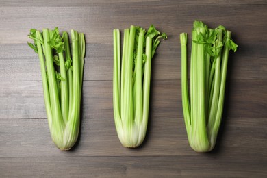 Fresh green celery stalks on wooden table, flat lay