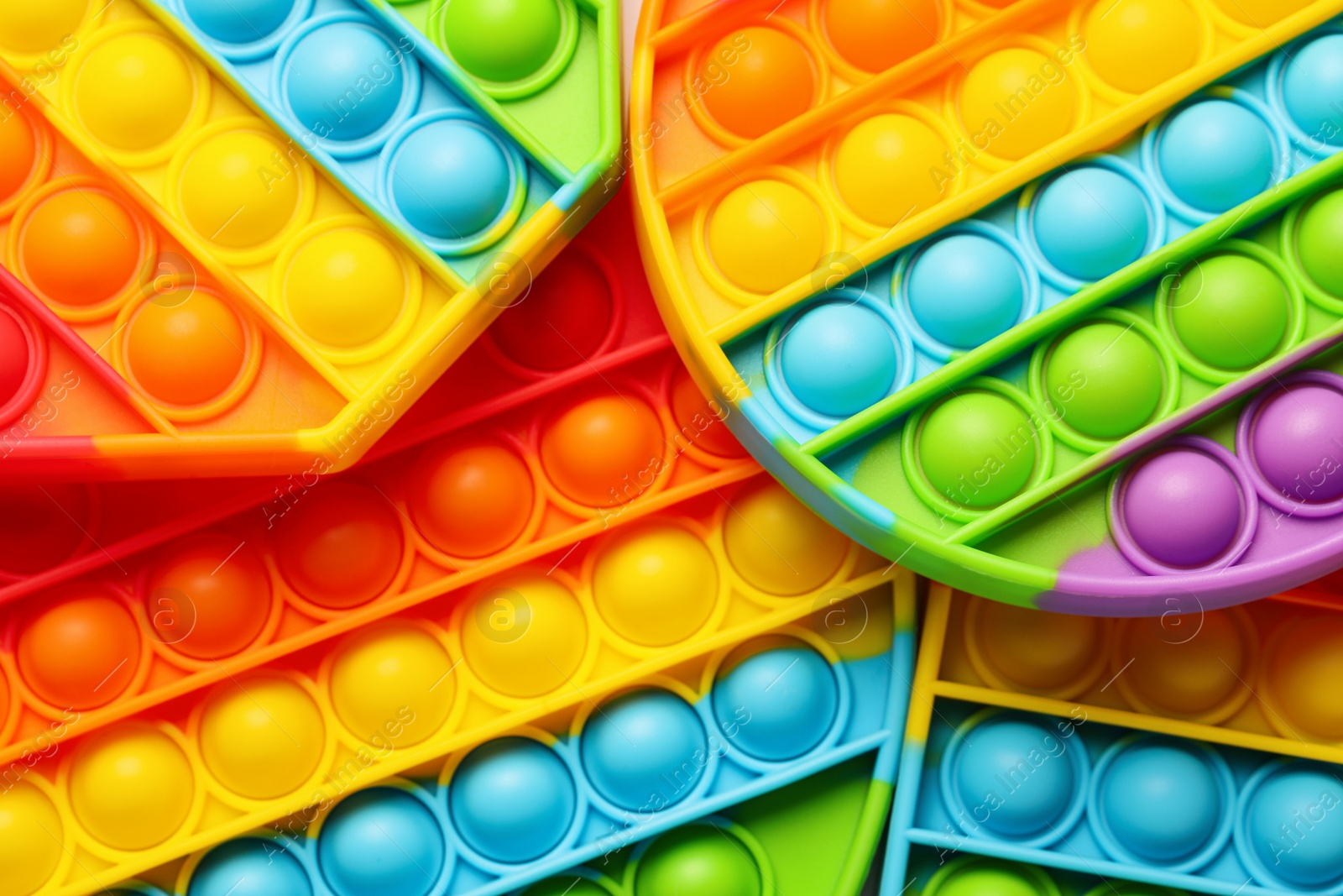 Photo of Rainbow pop it fidget toys as background, closeup