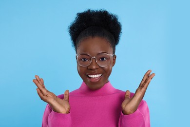 Photo of Portrait of beautiful young woman in eyeglasses on light blue background