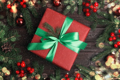 Image of Flat lay composition with red Christmas gift box on wooden table