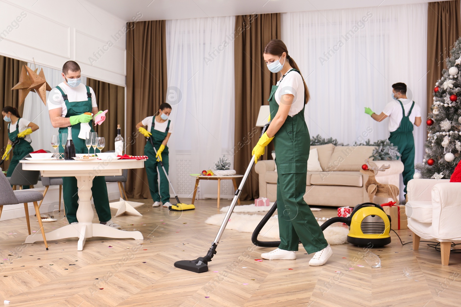 Photo of Cleaning service team working in messy room after New Year party