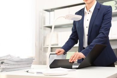 Woman working with documents at table in office, closeup