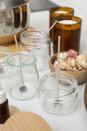 Photo of Glass jars with wicks on white kitchen table. Making homemade candles