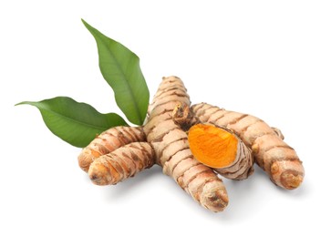 Photo of Fresh turmeric roots and green leaves isolated on white