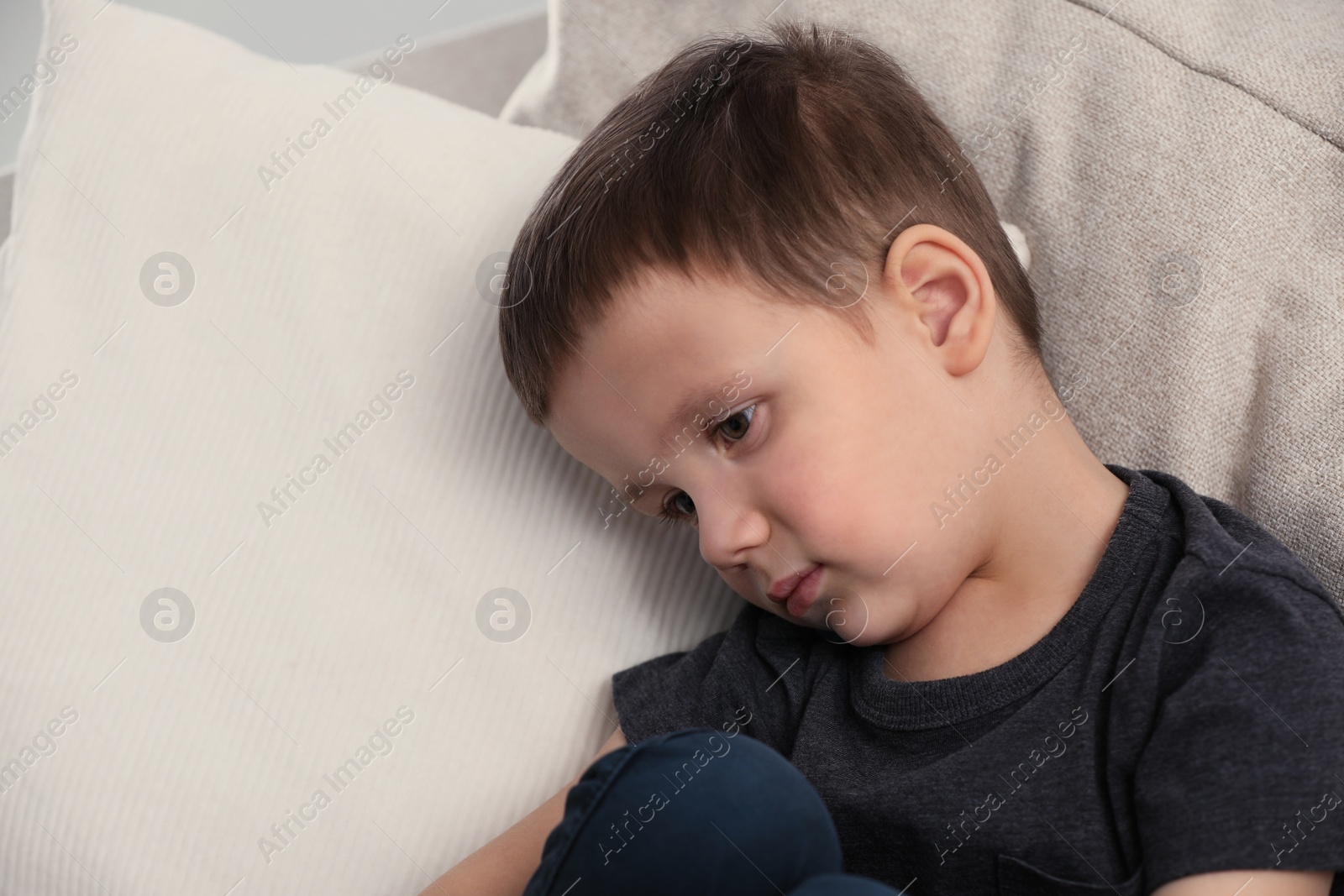 Photo of Sad little boy on sofa at home