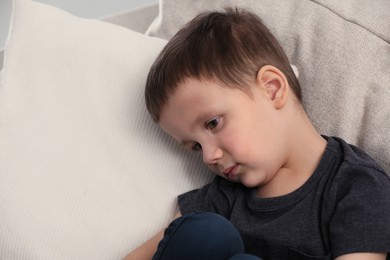 Photo of Sad little boy on sofa at home