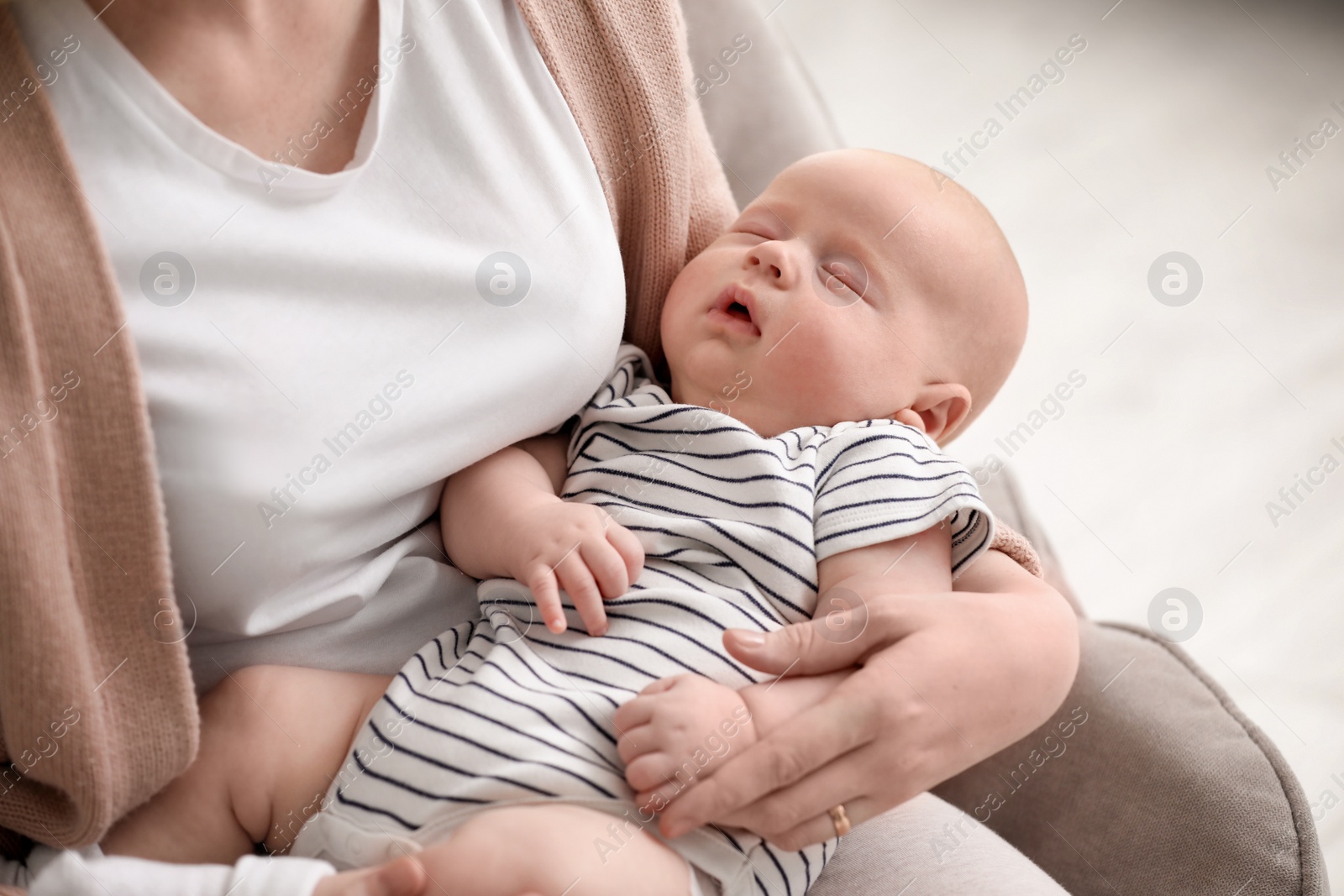 Photo of Mother with her sleeping baby at home