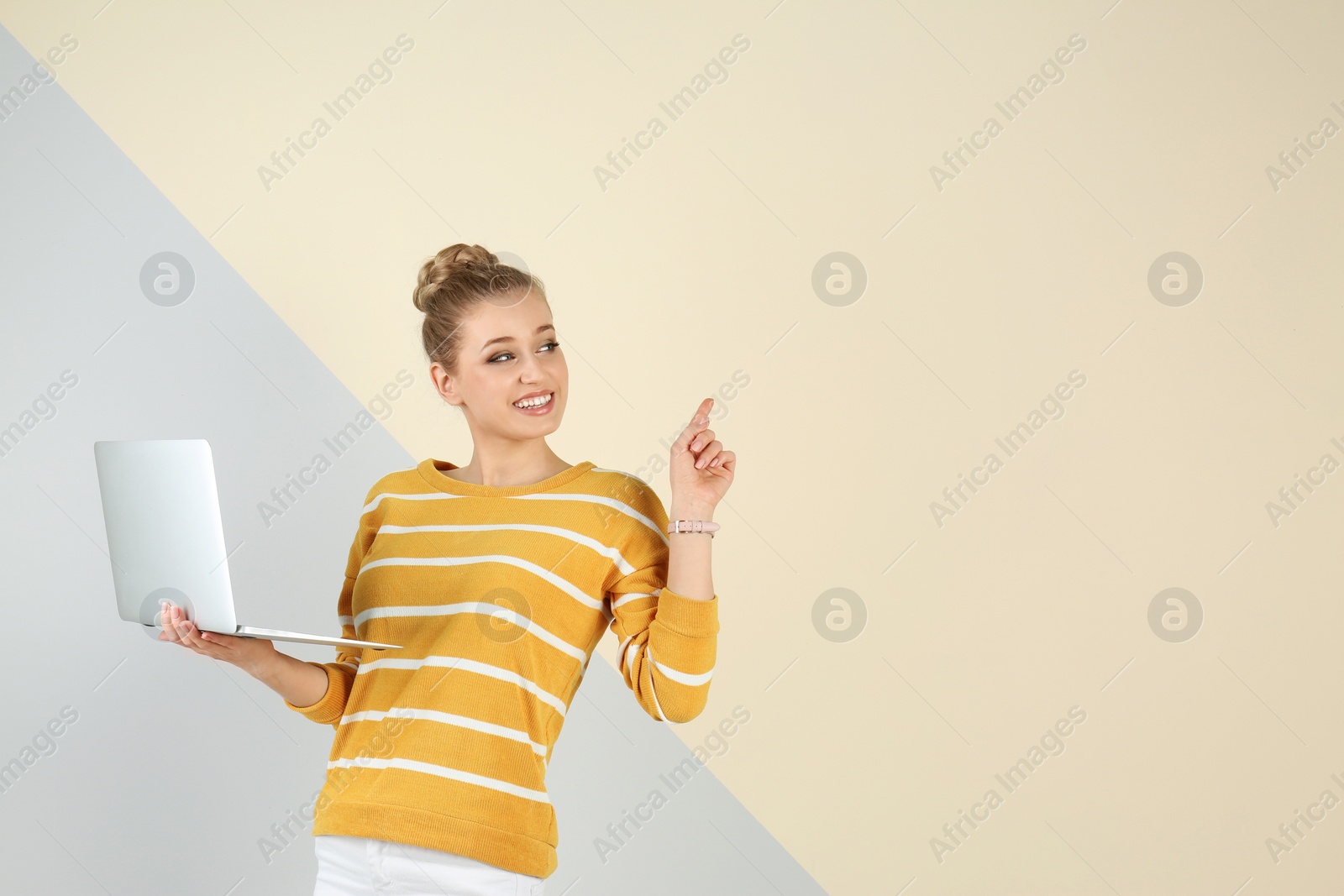 Photo of Portrait of beautiful young woman with laptop on color background. Space for text