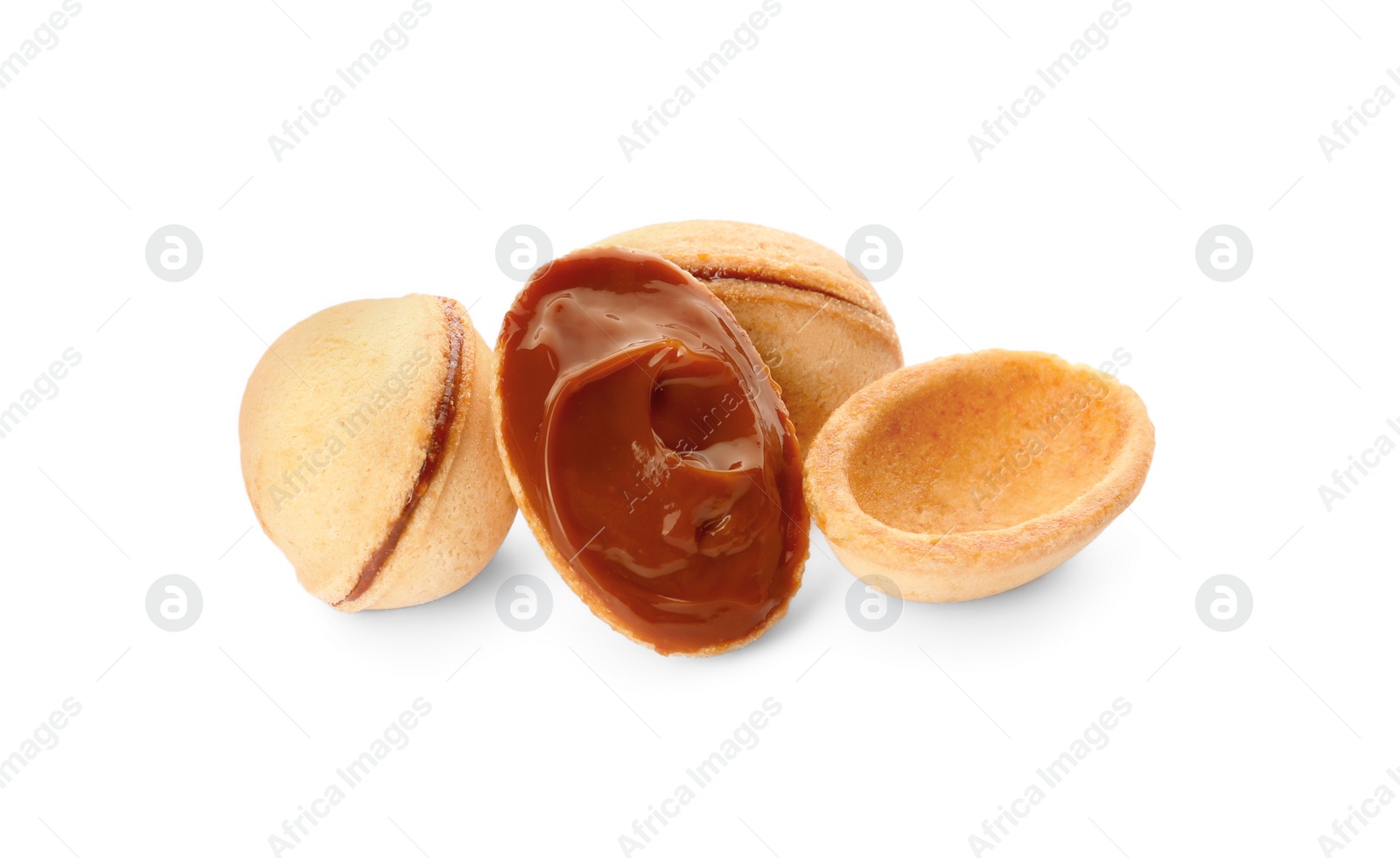 Photo of Delicious nut shaped cookies with boiled condensed milk on white background